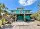 Charming two-story beach house with a wooden deck and staircase, perfect for enjoying coastal living at 9580 Almirate Ct, Placida, FL 33946