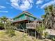 Two-story beach house featuring a wooden deck, offering a perfect blend of comfort and coastal charm at 9580 Almirate Ct, Placida, FL 33946
