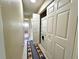 Hallway with tiled floors leading to a laundry closet featuring a stacked washer and dryer at 9580 Almirate Ct, Placida, FL 33946