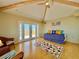 Living room with vaulted ceilings, exposed beams, and doors leading to a deck at 9580 Almirate Ct, Placida, FL 33946