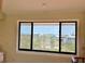 View from window showcases beautiful scenery with greenery and rooftops under a clear sky, creating a serene atmosphere at 9580 Almirate Ct, Placida, FL 33946