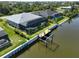Aerial view of a home featuring a dock, a pool, and lush landscaping on a waterfront lot at 10115 Long Branch St, Port Charlotte, FL 33981