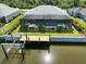 An aerial view of the home with a pool, dock, and screened lanai at 10115 Long Branch St, Port Charlotte, FL 33981