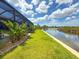 Lush backyard with direct access to the water, featuring a concrete seawall and well-maintained lawn at 10115 Long Branch St, Port Charlotte, FL 33981