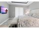 Serene bedroom with a plush bed, accent bench, flat screen TV, and natural light at 10115 Long Branch St, Port Charlotte, FL 33981