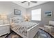 Cozy bedroom with white furniture, nautical themed bedding, a ceiling fan and a large area rug at 10115 Long Branch St, Port Charlotte, FL 33981