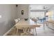 A dining room with wooden flooring and a long table next to a living room and outdoor living space at 10115 Long Branch St, Port Charlotte, FL 33981