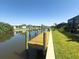 Waterfront home featuring a private boat dock with a lift, set along a scenic canal with lush landscaping at 10115 Long Branch St, Port Charlotte, FL 33981