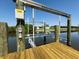 Up-close detail of a boat lift on a private wooden dock, highlighting its functionality and convenience for boat owners at 10115 Long Branch St, Port Charlotte, FL 33981