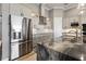 A bright kitchen featuring stainless steel appliances, a marble countertop, and white cabinets at 10115 Long Branch St, Port Charlotte, FL 33981