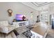 A living room featuring cozy furniture, a modern fireplace, and access to the kitchen and dining room at 10115 Long Branch St, Port Charlotte, FL 33981