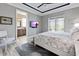 View of a main bedroom with a king bed and an ensuite bath visible through an open door at 10115 Long Branch St, Port Charlotte, FL 33981