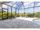 Enclosed pool area with lush, mature landscaping and a beautiful view of the pond at 10115 Long Branch St, Port Charlotte, FL 33981