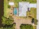 Aerial view showcases backyard with pool, private dock, manicured lawn, and lush landscaping at 10182 Charlemont Ave, Englewood, FL 34224