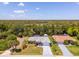 Scenic aerial view of a home with a screened-in pool, waterfront access, and tropical landscaping at 10182 Charlemont Ave, Englewood, FL 34224