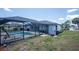 Relaxing backyard pool area with screened enclosure, poolside seating and a view of the home's exterior at 10182 Charlemont Ave, Englewood, FL 34224