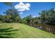 Green backyard area with waterfront views, providing a tranquil outdoor space at 10182 Charlemont Ave, Englewood, FL 34224