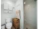 Charming bathroom featuring a shower, toilet, cabinet, and a woven basket at 10182 Charlemont Ave, Englewood, FL 34224