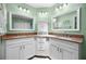 Bright bathroom features double sinks, granite countertops, and white cabinets at 10182 Charlemont Ave, Englewood, FL 34224