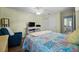Comfortable bedroom features hardwood floors, ample natural light, closet, and blue chair at 10182 Charlemont Ave, Englewood, FL 34224