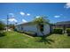 Exterior view of house featuring a well-kept lawn, tropical palm, and screened patio at 10182 Charlemont Ave, Englewood, FL 34224