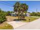 Well maintained single story house with palm trees, a driveway, green grass and manicured landscaping at 10182 Charlemont Ave, Englewood, FL 34224