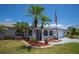 Charming home exterior with well-maintained landscaping, palm trees, and an American flag display at 10182 Charlemont Ave, Englewood, FL 34224