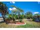 Well-landscaped front yard featuring manicured plants, palm trees, and decorative mulch beds at 10182 Charlemont Ave, Englewood, FL 34224