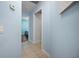 Hallway showcasing tiled floors, neutral wall color, and open doorways to bedrooms at 10182 Charlemont Ave, Englewood, FL 34224