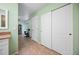 Hallway view with closet, view to desk, tile flooring, and neutral colored walls at 10182 Charlemont Ave, Englewood, FL 34224