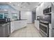 Bright kitchen with white cabinetry, stainless steel appliances, and tile flooring at 10182 Charlemont Ave, Englewood, FL 34224