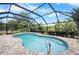 Cool and refreshing pool with blue skies, surrounded by brick pavers at 10182 Charlemont Ave, Englewood, FL 34224