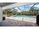 Screened-in pool with brick pavers, surrounded by lush landscaping at 10182 Charlemont Ave, Englewood, FL 34224