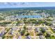 Expansive aerial view showcasing the residential neighborhood, lake, and surrounding trees at 1035 Riggs St, Port Charlotte, FL 33952