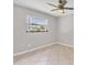 Bright bedroom features a ceiling fan and a large window with a pleasant neighborhood view at 1035 Riggs St, Port Charlotte, FL 33952
