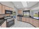 Bright kitchen with stainless steel appliances, black countertops, and tile floors at 1035 Riggs St, Port Charlotte, FL 33952