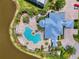 Overhead view of a beautiful community pool, building, manicured landscape, and adjacent parking at 10411 Coral Landings Ln # 85, Placida, FL 33946