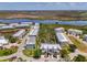 Aerial view of townhouse in a waterfront community near a pond, landscaping, and winding roads at 10411 Coral Landings Ln # 85, Placida, FL 33946