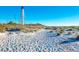 Beach view with a tall lighthouse on the horizon at 10411 Coral Landings Ln # 85, Placida, FL 33946