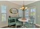 Bright dining area with light blue accents, a round table, and natural light from two windows at 10411 Coral Landings Ln # 85, Placida, FL 33946