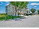 Inviting multi-story townhouse with a two-car garage, lush lawn, and mature trees at 10411 Coral Landings Ln # 85, Placida, FL 33946