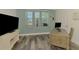 Office space featuring a wooden desk, television, and natural light from the nearby windows at 10411 Coral Landings Ln # 85, Placida, FL 33946