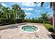 Relaxing hot tub surrounded by lush tropical landscaping and a beautiful brick patio at 10411 Coral Landings Ln # 85, Placida, FL 33946