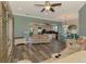 Open-concept living room featuring hardwood floors, ceiling fan, and views into the kitchen and dining area at 10411 Coral Landings Ln # 85, Placida, FL 33946