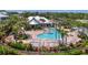 Community pool featuring lush landscaping, lounge chairs, and shade for relaxing in the sun at 10411 Coral Landings Ln # 85, Placida, FL 33946