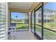 Screened porch with view of a manicured lawn, landscaping, and multi-story building at 10411 Coral Landings Ln # 85, Placida, FL 33946
