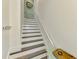 Staircase with wood treads, white risers, and white handrail, with coastal decorations at 10411 Coral Landings Ln # 85, Placida, FL 33946