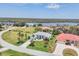 Aerial view of light blue home with lush front yard, palm trees, and a view of the nearby water at 11 Amberjack Ln, Placida, FL 33946