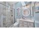 Updated bathroom featuring a tiled walk-in shower, round mirror, and modern vanity at 11 Amberjack Ln, Placida, FL 33946
