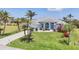 Beautiful one-story home with well-manicured lawn, lush landscaping, and a light blue exterior paint at 11 Amberjack Ln, Placida, FL 33946